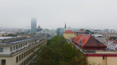 Çek Cumhuriyeti 'nin Brno kentinin çatılarında süzülen kuşlar sisle kaplı bir bulvarı ve gökdeleni aydınlatarak sakin ve atmosferik bir şehir manzarası yaratıyor..