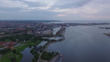 Kopenhag Limanı 'nda güneş ışığı banyosu ve alacakaranlıkta ufuk çizgisi nefes kesici bir manzara yaratır. Su, batan güneşin canlı renklerini yansıtır, dingin atmosferi güçlendirir..