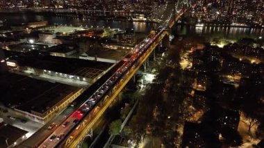 Arabalar, New York 'ta Manhattan ve Queens' i birbirine bağlayan Queensboro Köprüsü 'nü aydınlattı. Çarpıcı bir şehir zeminine karşı hareketli bir gece sahnesi trafiği hareketlendiriyor.