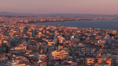 Sıcak turuncu güneş ışığı, Yunanistan 'ın Selanik kentinin sokaklarını ve binalarını bu hava manzarasıyla yıkıyor. Arka planda Termaik Körfez ve Ege Denizi görülebilir.