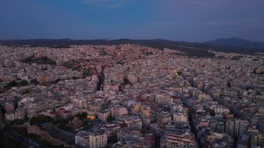 Selanik 'in hava manzarası, mavi saatin Yunan şehrine inmesiyle yavaş yavaş aydınlanıyor. Makedonya ve Trakya Bakanlığı 'na doğru giden ana yoldan otomobiller ilerliyor.