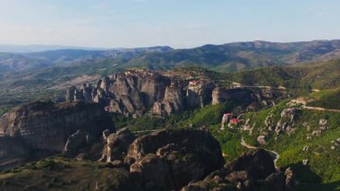 Gökyüzü manzaraları Yunanistan 'daki çarpıcı Meteora kaya oluşumlarını ön plana çıkarıyor, görkemli kayalıklara tünemiş canlı yeşillikler ve antik manastırlar sergiliyor.