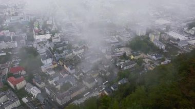 Alçak bulutlar yavaşça Salzburg, Avusturya 'ya doğru hareket ediyor. Sis çöktüğünde binalar ve sokaklar görülebilir..