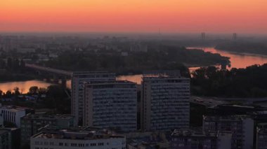 Vistula Nehri 'nin hava görüntüsü Polonya' nın Varşova şehrinde gün doğumunda gökyüzünü yansıtıyor. Kamera yavaşça soldan sağa döner.