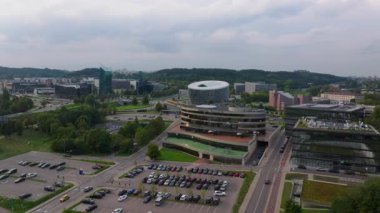 Litvanya 'nın Vilnius şehrinde çatıda basketbol sahası olan Forum Palace adlı modern bir binanın etrafında dönen hava manzarası. Aşağıdaki caddelerde arabalar sürüyor..