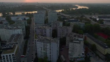 Hava görüntülerine göre Vistula Nehri ve Polonya 'nın Varşova kentinde bir yerleşim alanı gündoğumunda sergilenmektedir. Sıcak günbatımı ışığı, binaları ve nehri sarar. Huzurlu ve güzel bir manzara yaratır..