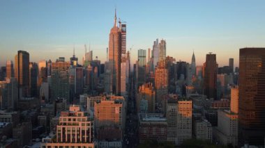 Manhattan şehir merkezinde ve New York 'taki Empire State Binası' nda güneşin batışını gösteren hava manzarası. Modern mimari gökdeleninde inşaat işçileri.