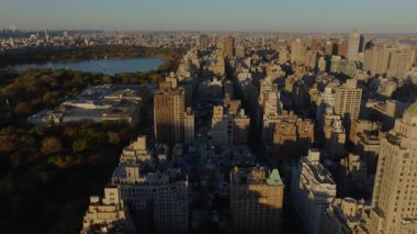 Hava görüntüleri, Central Park ve Jacqueline Kennedy Onassis Reservoir yakınlarındaki binalardan yansıyan güneş ışığını yakalıyor ve New York şehrinin dinamik kentsel manzarasını gösteriyor..