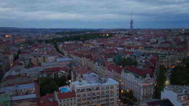 Prag ufuk çizgisinde kameralar yankılanıyor, Zizkov Televizyon Kulesi 'ni gösteriyor şehrin ortasında alacakaranlık sıcacık parıltısıyla yıkanmış..