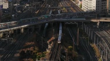 Metropolitan metro treni yükseltilmiş demiryolunda ilerliyor, New York City 'de güneşli gökyüzü altında yayılan tren istasyonu..