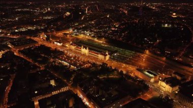 Prag ana tren istasyonu Praha Hlavni Nadrazi 'nin hava manzarası. Çevredeki caddelerde hareket halindeki arabalar ve binaları aydınlatan ışıklar var..