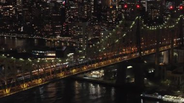 Gece vakti aydınlık Queensboro Köprüsü 'nden geçen arabalar Manhattan ve Queens' in New York ilçelerini birbirine bağlıyor..