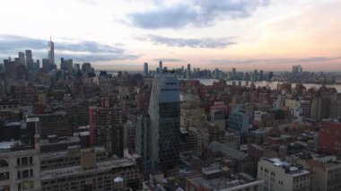 Havadan bakıldığında New York Citys ikonik ufuk çizgisini vurguluyor, Hudson Nehri üzerinde güneş batıyor, şehir manzarasını canlı renklerle boyuyor ve yüksek binaları aydınlatıyor..