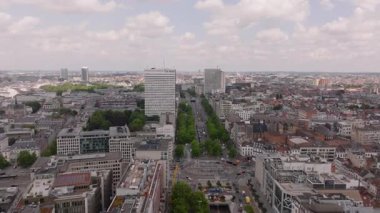 Ağaçlar ve binalarla dolu uzun bir bulvarı olan hareketli bir Avrupa şehrinin havadan görünüşü. Arabalar yolda, yayalar kaldırımlarda yürüyor..