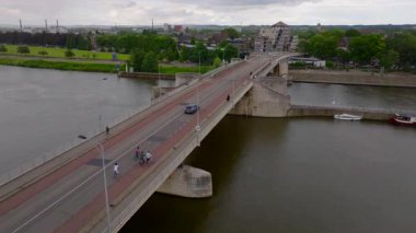 Maastricht 'teki Wilhelminabrug köprüsünün hava görüntüsü, nehir manzaralı bir arka planda arabalar ve yayalar var..