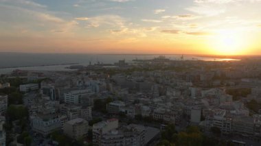 Yunanistan 'daki Selanik silueti üzerinde sersemletici bir günbatımı ışıltısı yansıtıyor. Termaik Körfez ve Liman, şehrin akşam cazibesini artırmak için pitoresk bir zemin oluşturur..