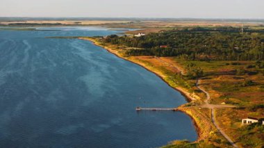 Ringkobing Fjord, Danimarka 'da güneşli ve açık bir günde Kuzey Denizi ile karşılaşır. Bu hava görüntüsü kıyı şeridini ve dalgaların buluşmasını gösteriyor..