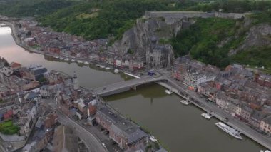 Belçika 'nın Dinant şehrinde, sağ kıyıda Meuse Nehri' nin üzerinden geçen araçların görüntüsü..