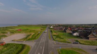 Ringkobing Fjord yakınlarındaki bir yolda giden arabaların hava görüntüsü. Kuzey Denizi ve Danimarka kırsal kesimi uzaktan görülebilir..