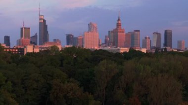Günbatımında Kültür ve Bilim Sarayı ile renk değiştiren modern gökdelenleriyle Varşova şehir merkezinin havadan görünüşü.