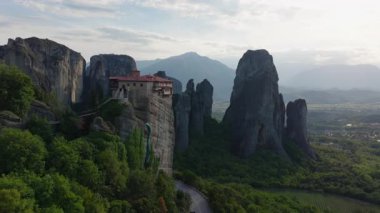 Havadan bakıldığında, Yunanistan 'ın Meteora kentindeki çarpıcı bir kaya oluşumuna tünemiş 16. yüzyıldan kalma Rousanou Manastırı' nın canlı yeşilliklerle kaplı olduğu görülüyor..