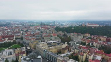 Havadan bakıldığında, kendine özgü mimarisini ve bulutlu gökyüzünün altındaki yeşil parklarını vurgulayan, kentsel yaşamı doğal güzelliklerle harmanlayan Brno kenti görülüyor..