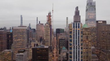 Sıcak altın güneş ışığı Manhattan 'ın göbeğinde parıldıyor, yükselen gökdelenlerin alacakaranlık gökyüzüne karşı siluetlerini ortaya çıkarıyor..