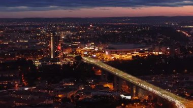 Prag Nusle Köprüsü 'nün hava manzarası. Alacakaranlıkta şehir manzarasını aydınlatan arabalar. Şehir manzarası, şehirlerin büyüleyici parıltısını gözler önüne seriyor..