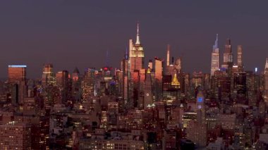 Görkemli gökdelenler ve kentsel ışıklar New York City 'nin Manhattan şehir merkezindeki gökyüzünü aydınlatıyor. Alacakaranlıkta nefes kesici bir manzara yaratıyor..