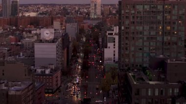 Manhattan 'a düşen alacakaranlık, gökdelenlerin önünden geçen trafik, parlayan billboardlar, kararan siluete karşı parlayan şehir enerjisi.
