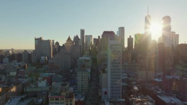 Altın güneş ışığı Soho alışveriş bölgesini ve Manhattan gökdelenlerini silip süpürüyor, ikonik New York şehrinin silueti boyunca kentsel sıcaklık yayıyor, mimari ihtişamı vurguluyor..