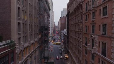 Manhattan caddesinde dokuma yapan araçlar inşaat iskelesi olan yüksek gökdelenlerin pencerelerinin yanından geçiyor..