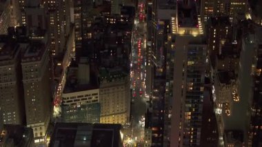 Gece vakti Manhattan caddesi trafikten parıldıyor, araçlar gökdelenler arasında zikzak çiziyor, şehir merkezlerinde ışık saçan kentsel enerji sergiliyor..