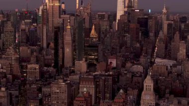 Manhattan şehir merkezindeki gökyüzü alacakaranlıkta parlıyor, Empire State Binası 'nı ele geçiriyor ve yükselen gökdelenler derinleşen akşam ışığına karşı aydınlanıyor..