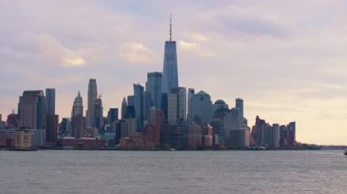 Hava görüntüsü, alacakaranlıkta parlayan Jersey şehrinin gökdelenlerini gösteriyor. Goldman Sachs Kulesi 'nin de içinde bulunduğu siluetli gökdelenler, parıldayan deniz manzarasının sınırını çiziyor..