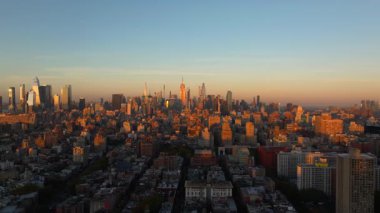 Empire State Binası ve Midtown Manhattan havadan izleniyor. Altın saat boyunca sıcak akşam ışığı ikonik gökyüzü ve şehir atmosferini sergiliyor..