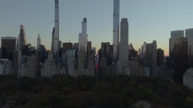 Güneş batarken Central Park 'ın güneyindeki hava manzarası ve arka planda Manhattan şehir merkezi silueti beliriyor..