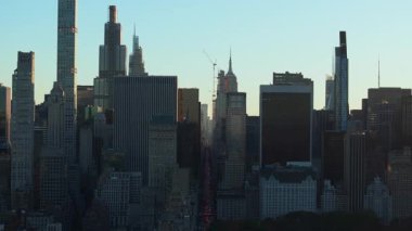 Hava görüntüsü, Manhattan şehir merkezindeki gökdelenleri aydınlatan güneşi ve 5. Cadde 'deki trafiği gösteriyor. Central Park, ön plandaki manzarayı görüntülüyor..