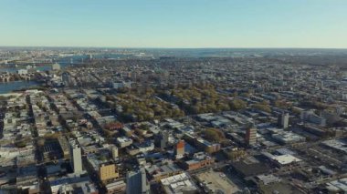 Queens, New York 'un şehir manzarası, arka planda Yukarı New York Körfezi ile sonbaharda renk değiştiren cadde, bina ve ağaçların şebeke modelini gösteriyor..