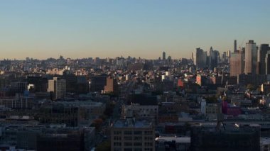 Geniş Queens borough, New York gökdelenleri, hareketli caddeleri, altın gün batımını aydınlatan metropoliten mimari manzaralı gökdelenler..