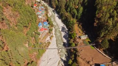 Jorsale vadisi kıvrımlı Dudh Kosi nehri, ahşap yapıları birbirine bağlayan asma köprü yemyeşil alanlar arasında Himalaya zirveleri yükseliyor.