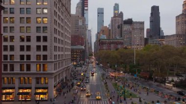 New York City silueti Madison Square Park ve Flatiron Bölgesi 'ni alacakaranlıkta yakalıyor, Beşinci Cadde' de yoğun bir trafik var..