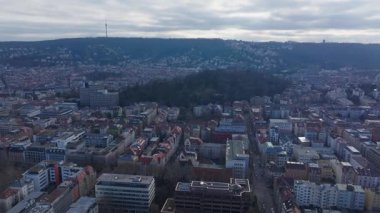 Stuttgart şehir manzarası, eski Allianz Binası, Televizyon Kulesi 'nin de dahil olduğu mimari manzarayı gözler önüne seriyor. Geniş bulutlu gökyüzü altında, ağaçlarla kaplı yeşil tepelerin arasından yükselen.