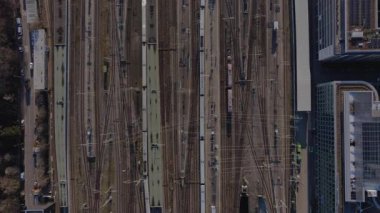 İstasyondan geçen yüksek hızlı beyaz tren, yukarıdan bakıldığında çağdaş kentsel arka plana karşı modern ulaşım altyapısını vurguluyor.