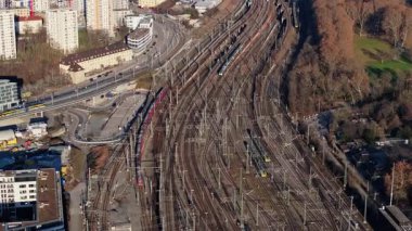 Stuttgart 'ın karmaşık demiryolu ağını gösteren hava görüntüleri, hareketli trenler ve çevreleyen şehir manzarasını vurguluyor.