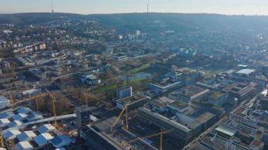 Stuttgarts kentsel manzarasının hava görüntüsü dönüşüm geçiriyor, Merkez Tren İstasyonu 'ndaki mevcut binalar arasında inşaat faaliyetlerini gösteriyor.