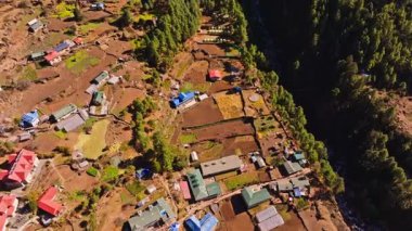 Hava manzarası, Everest Dağı yakınlarında yemyeşil ormanlarla çevrili Himalaya 'nın ücra bir köyü olan Monjo' nun Nepal 'in engebeli arazilerini ve geleneksel dağ yerleşimlerini kapsadığını gösteriyor..