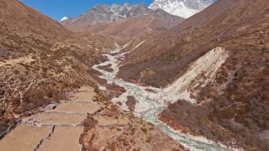 Karla kaplı Everest Dağı kıvrımlı nehrin üzerinde yükseldi, Himalaya Vadisi 'nde kayalık yollar açtı, Dingboche Yolu' nda Nepal 'in vahşi doğasını sergiledi..