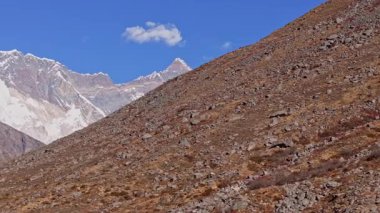 Everestler 'in kar zirvesinin gökyüzüne karşı görkemli bir şekilde yükseldiğini gösteren hava görüntüleri, engebeli kayalık yamaçların Nepal' deki dramatik Himalaya manzarasını çerçevelediğini gösteriyor..