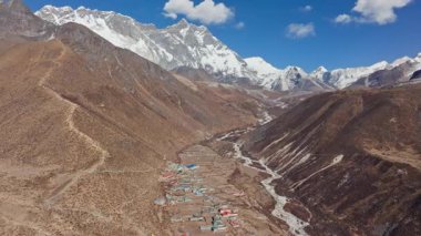 Sessiz Nepal yerleşim yeri Dingboche 'un üzerinde beliren devasa Everest Dağı kayalık Himalaya arazisinden yükselen karla kaplı tepe..